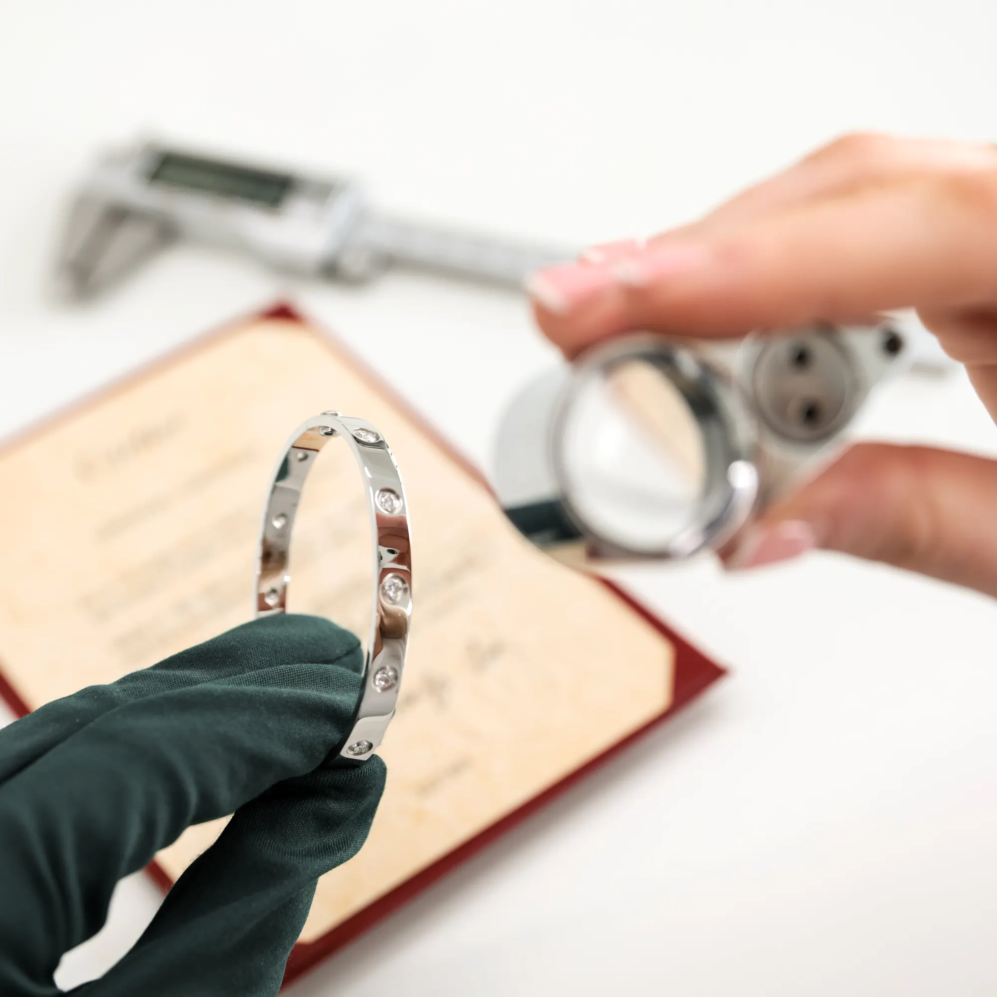 Pre-loved Cartier 18ct White Gold LOVE Bangle being authenticated by the Xupes team with equipment wearing gloves.
